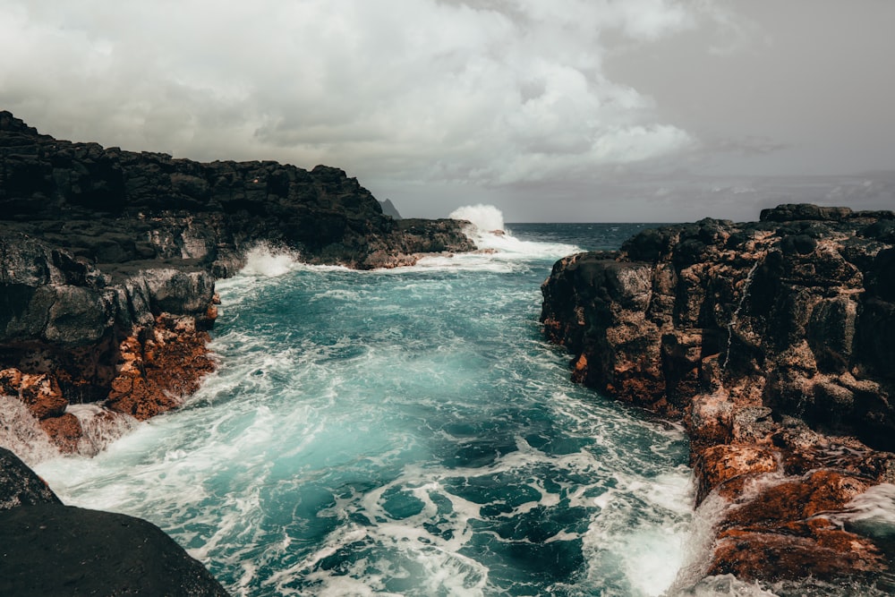 ocean waves crashing on rocky shore during daytime