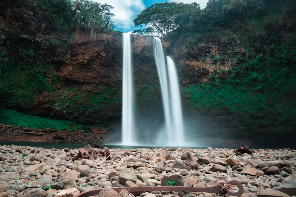 waterfalls on rocky ground under blue sky during daytime