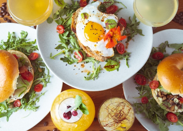 Egg with tomato and green leaf vegetable on white ceramic plate