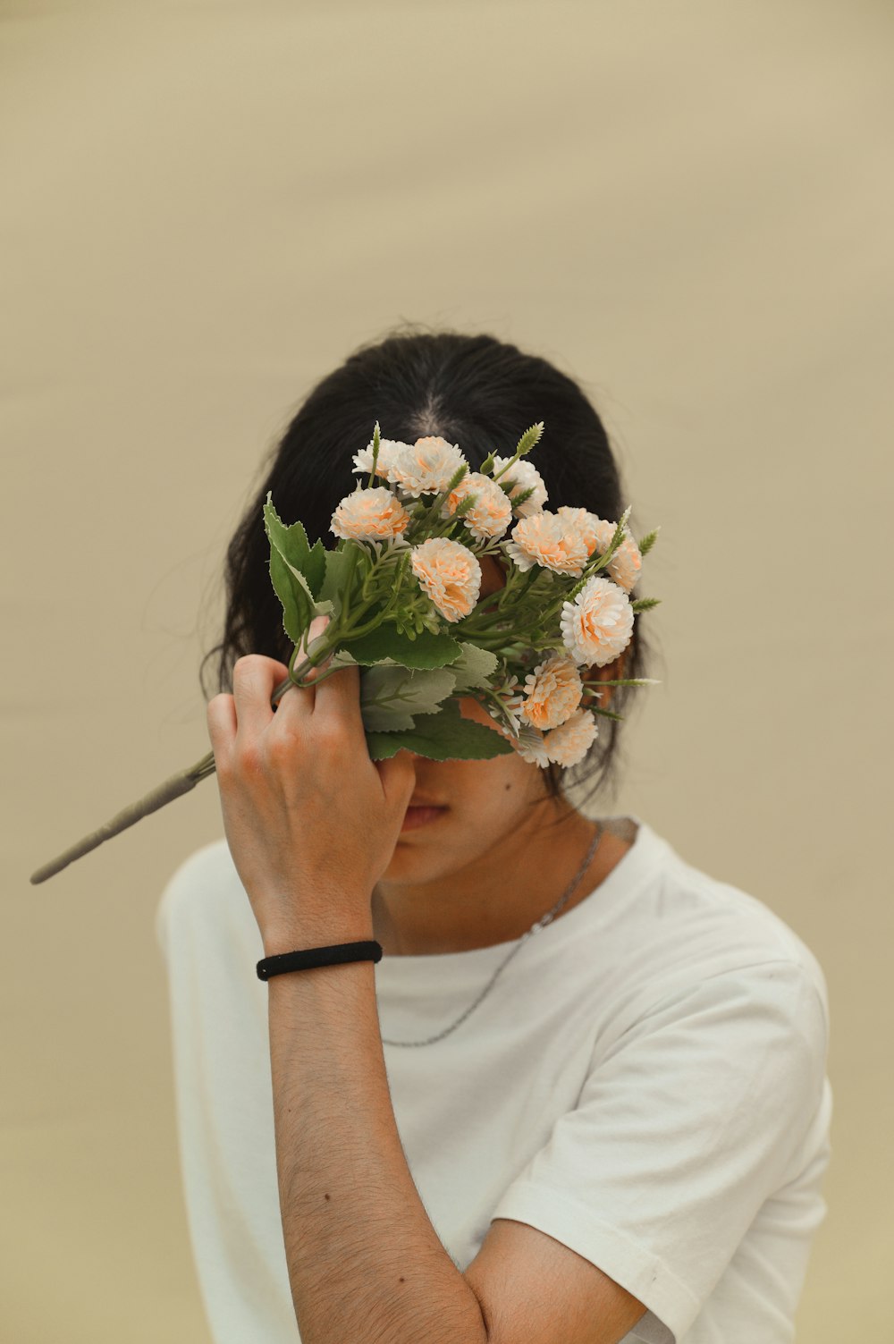 woman in white crew neck t-shirt holding bouquet of flowers