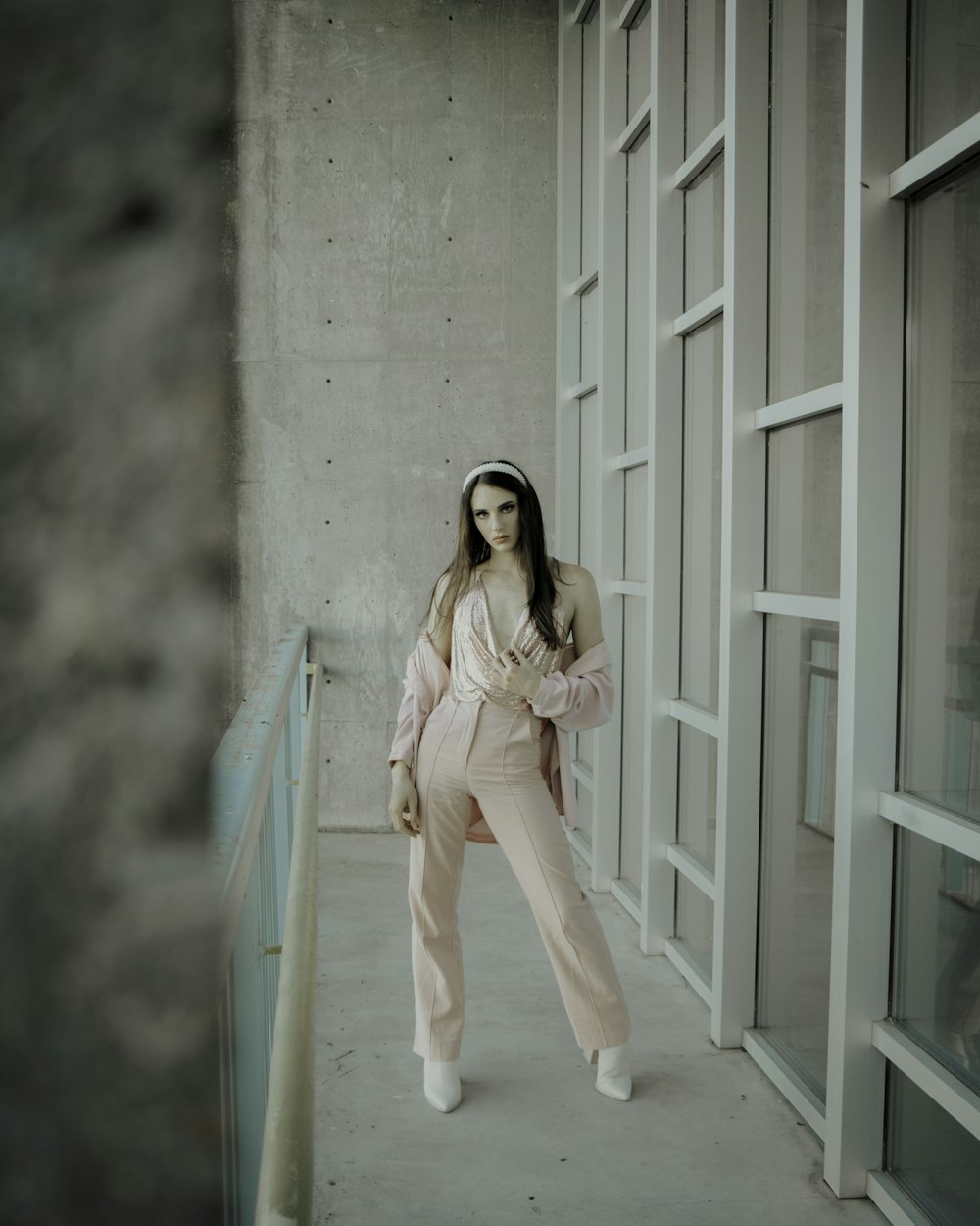 woman in pink long sleeve shirt and white pants standing on white wooden floor