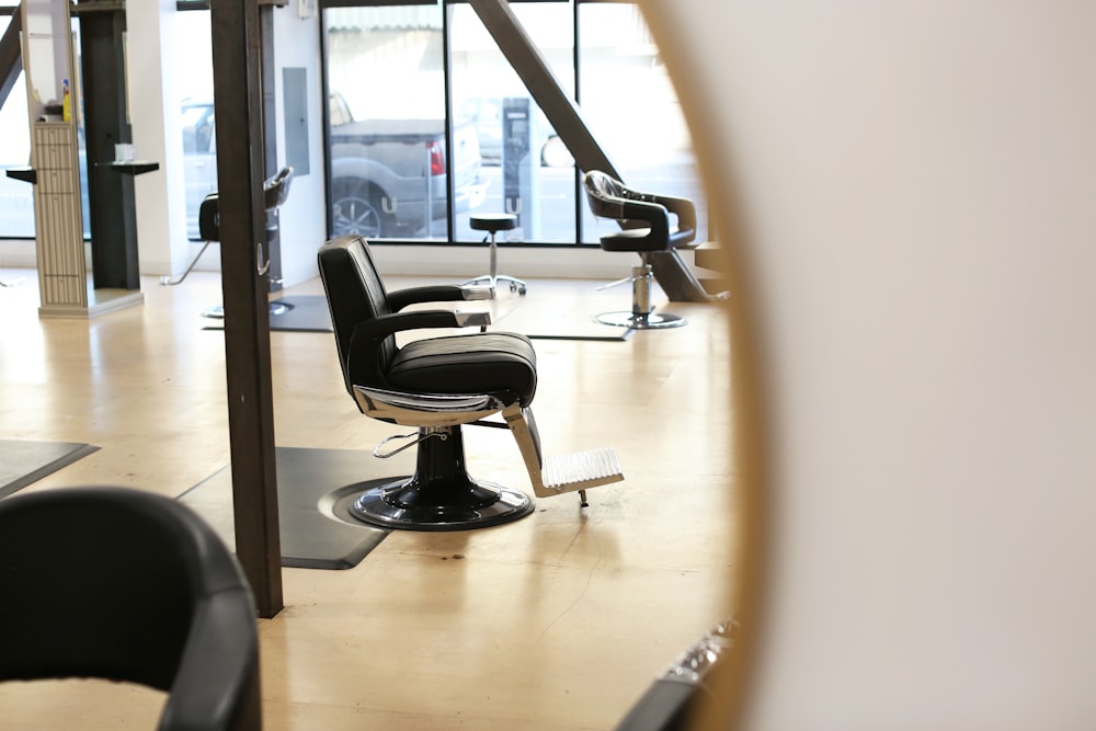 black leather barber chair near glass window