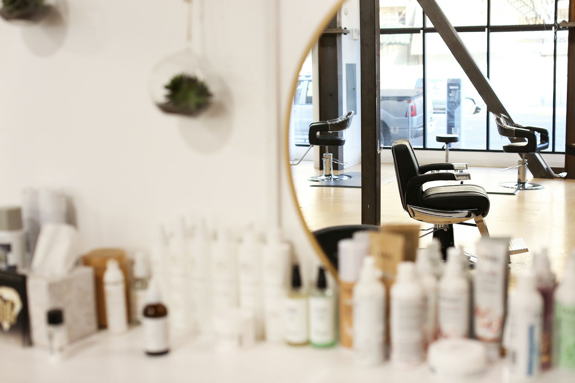 Image of a hair salon with a large mirror and lots of bottles of hair products