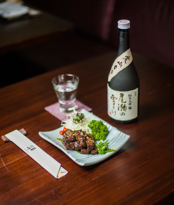 Botella de sake tradicional sobre mesa de madera