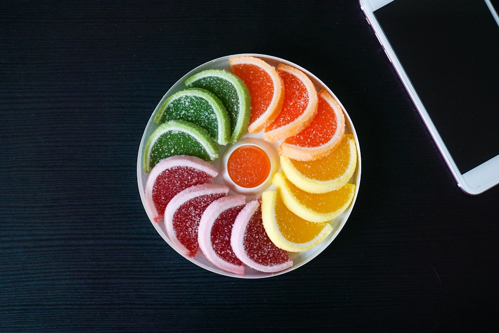 sliced orange fruit on white ceramic bowl