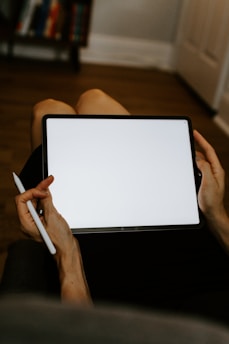 A person using a tablet to explore educational apps in a cozy study environment.