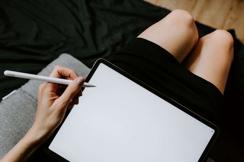 person holding pen and white paper