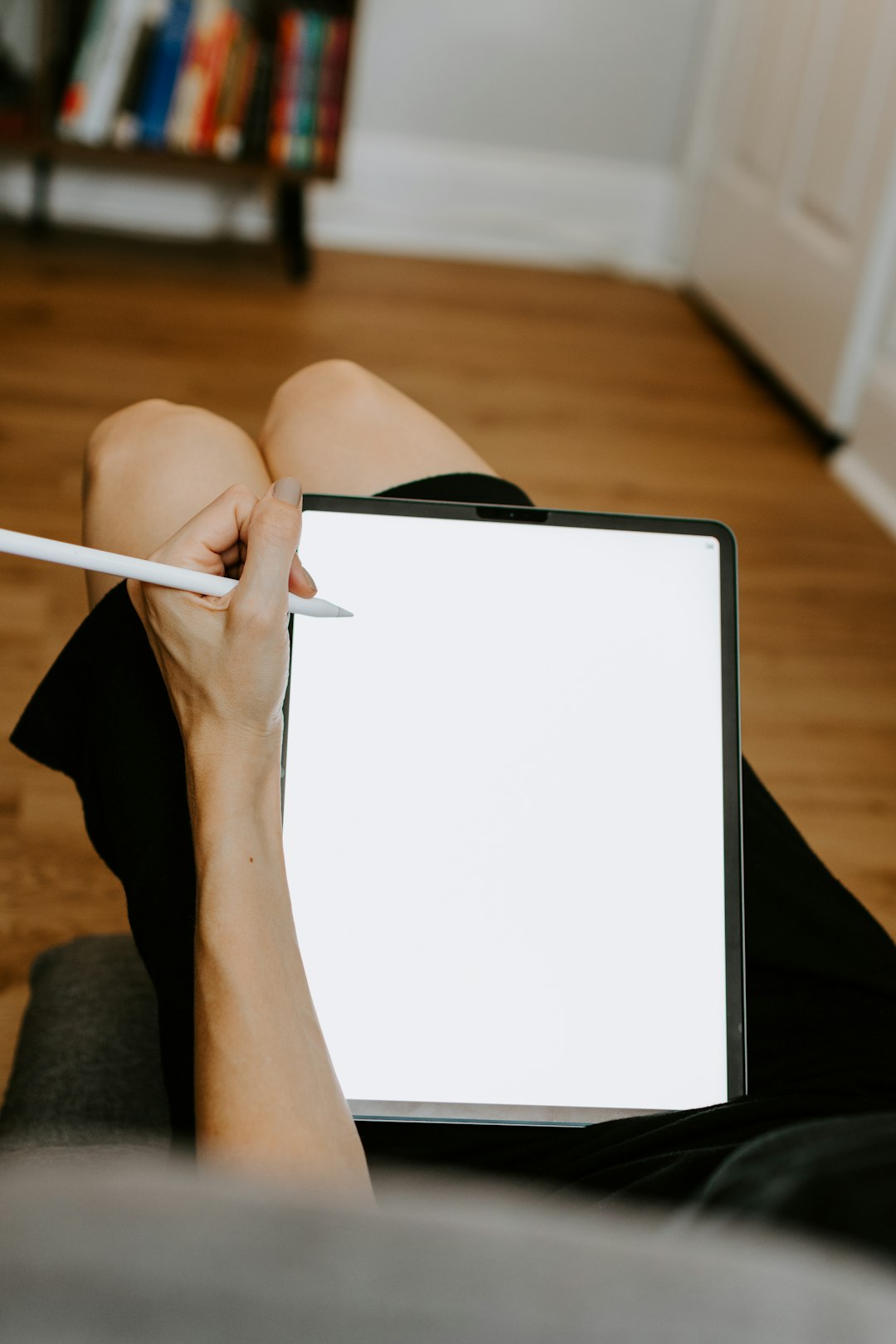 person in black shorts holding white tablet computer