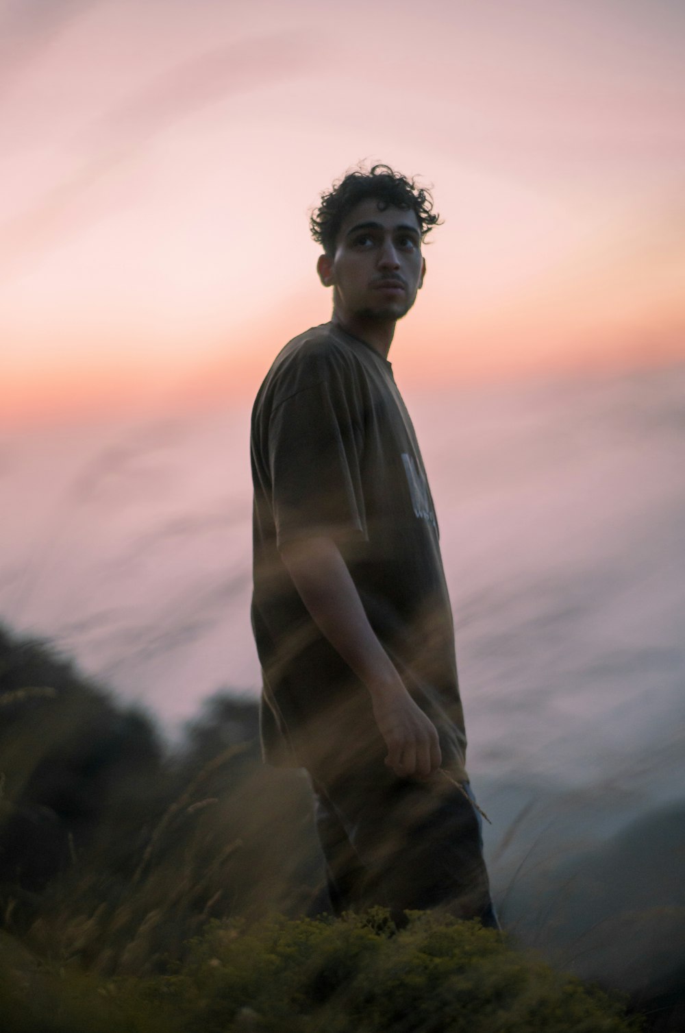 man in gray shirt standing during sunset