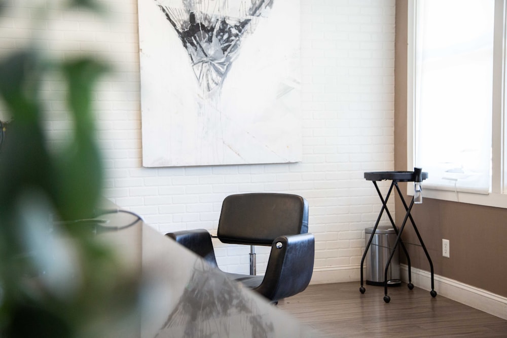 black and gray chair beside white wall