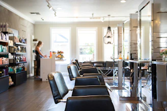 woman in white shirt standing near black leather chairs