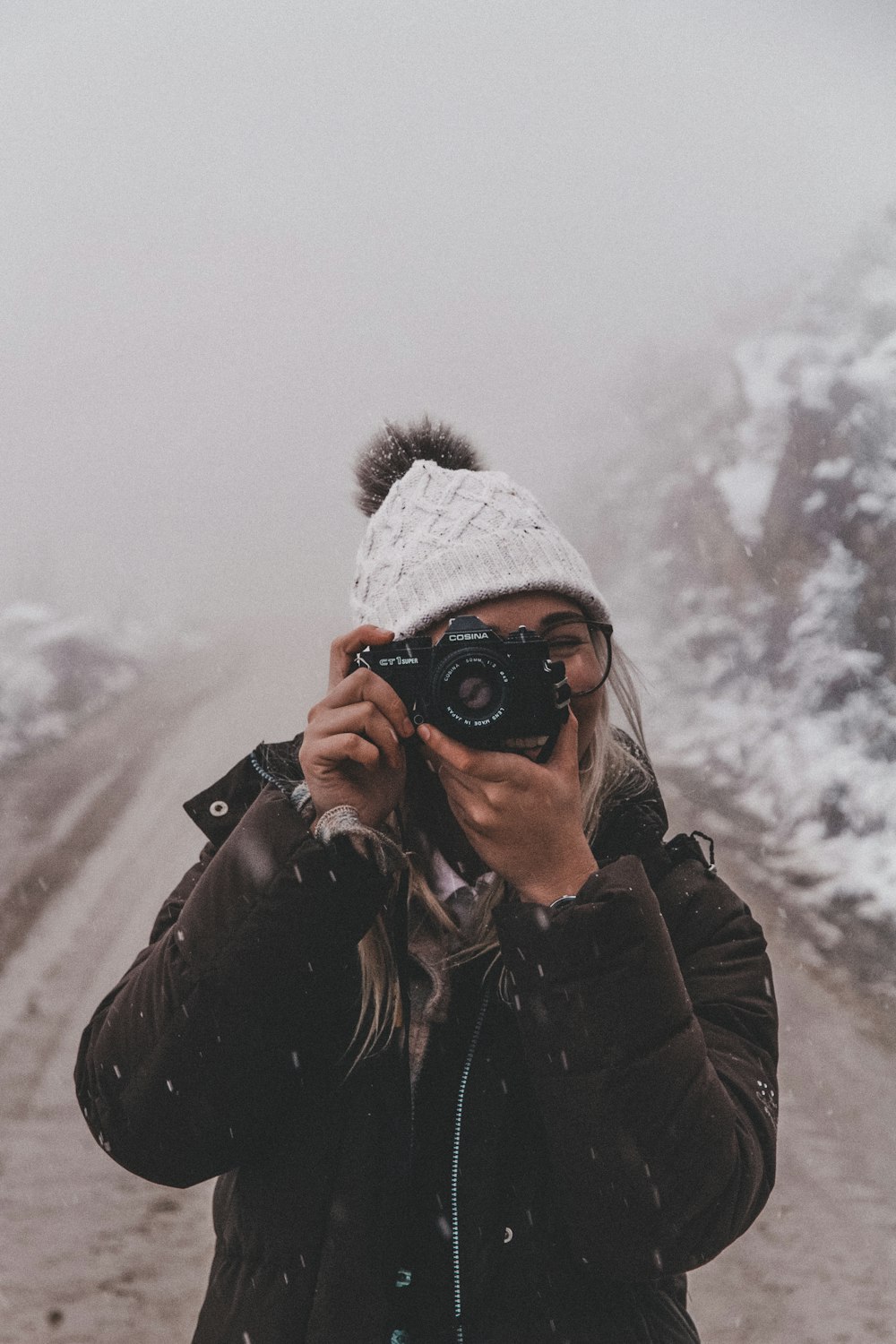 woman in black jacket holding black dslr camera