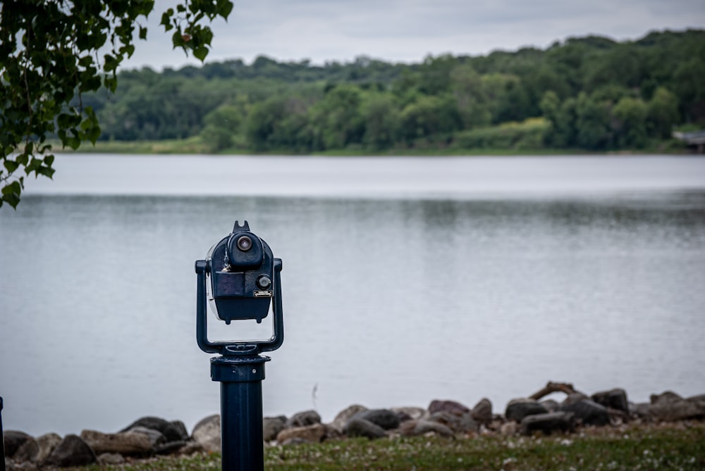 black and gray coin operated telescope on rocky shore during daytime