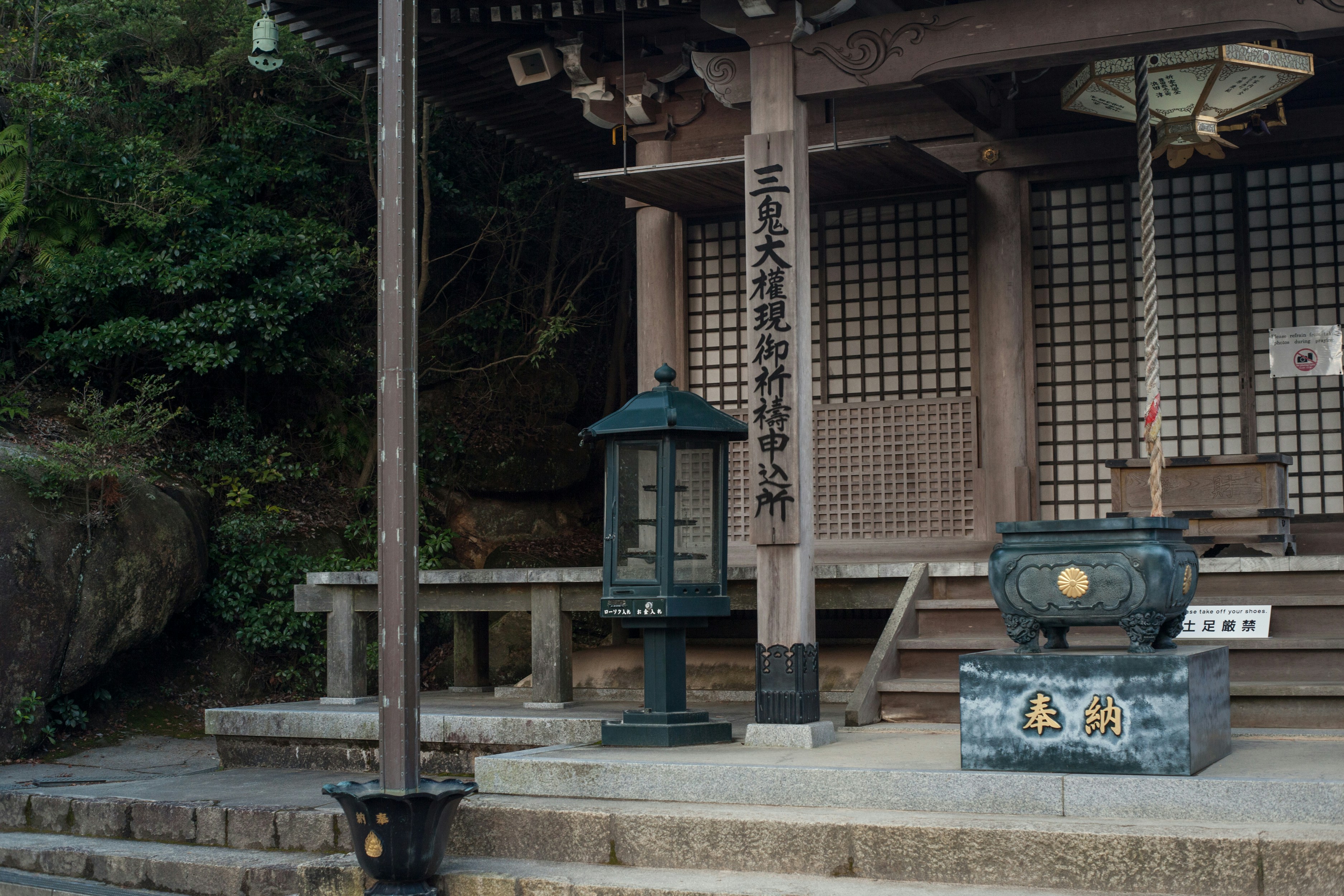 Main hall of a Japanese shrine with an offerings box and bell