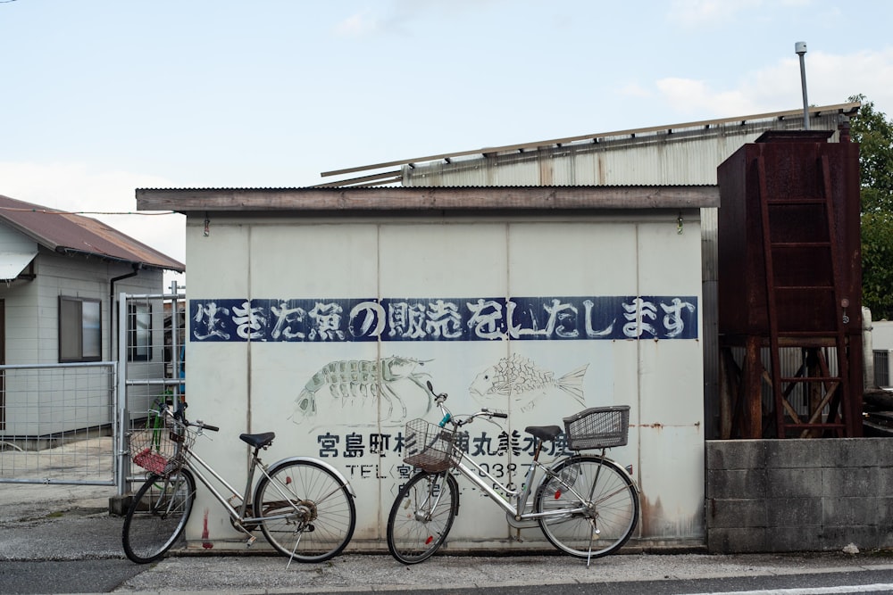bici da città nera parcheggiata accanto al muro bianco e blu