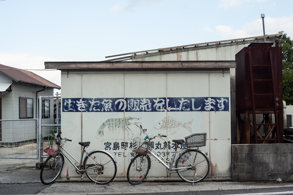 black city bike parked beside white and blue wall