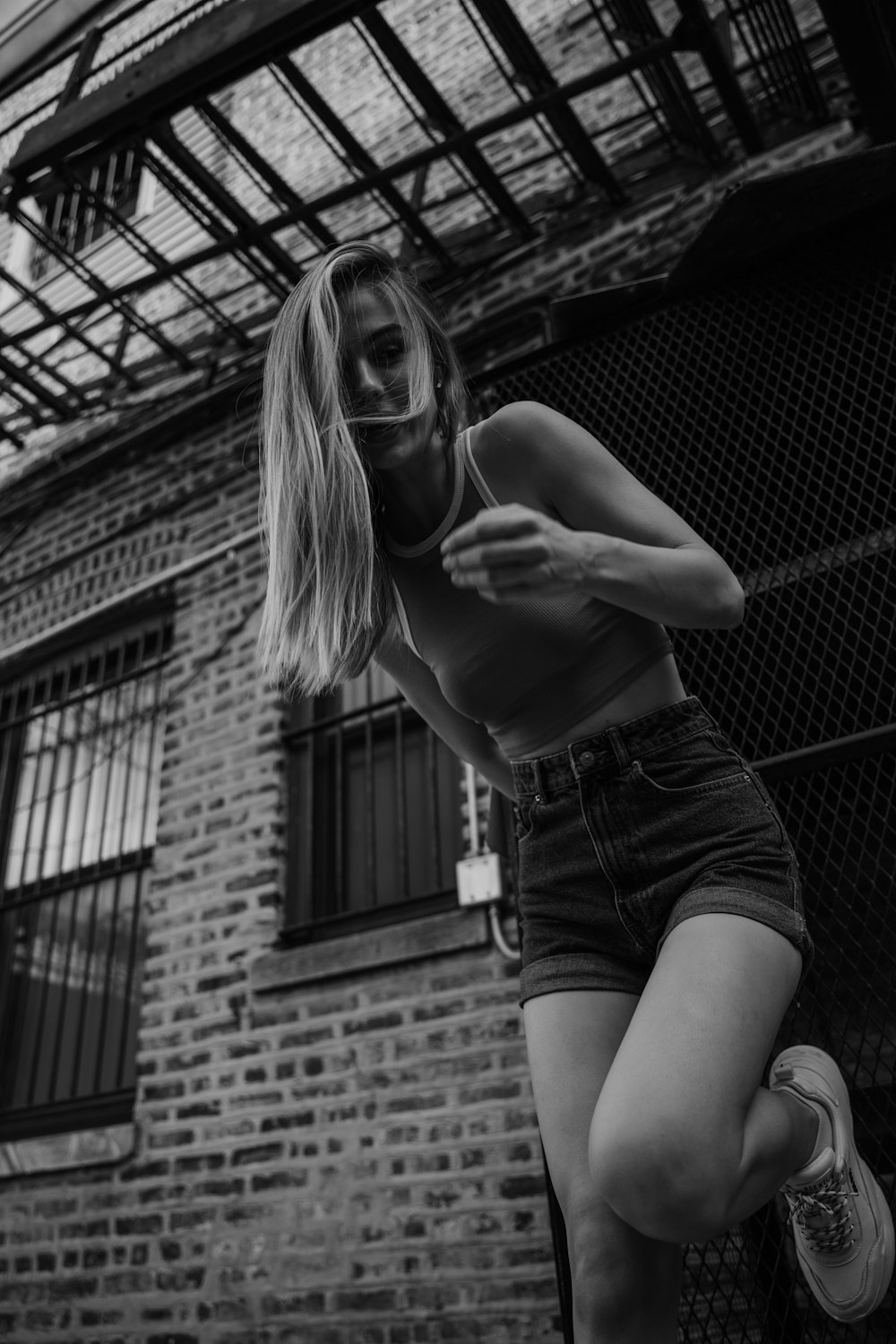 grayscale photo of woman in tank top and denim shorts