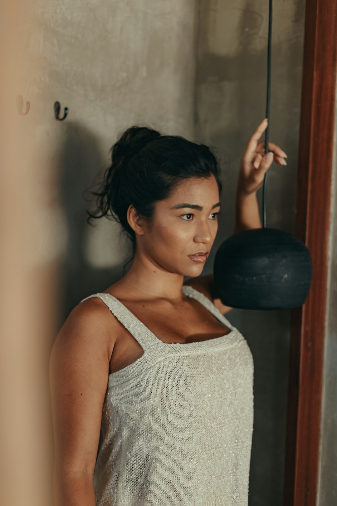 woman in white tank top holding black ball