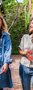 woman in blue denim jacket standing beside woman in white shirt