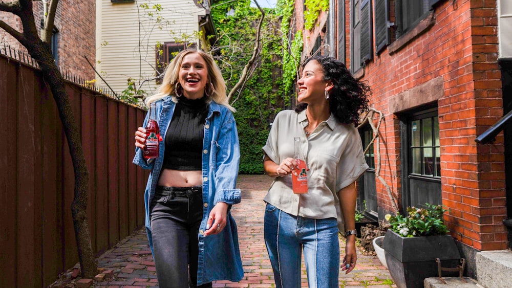 woman in blue denim jacket standing beside woman in white shirt