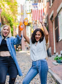 2 women standing on brown brick floor during daytime