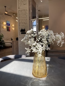 A luxurious cement vase with fresh flowers brightening a cozy living room corner.