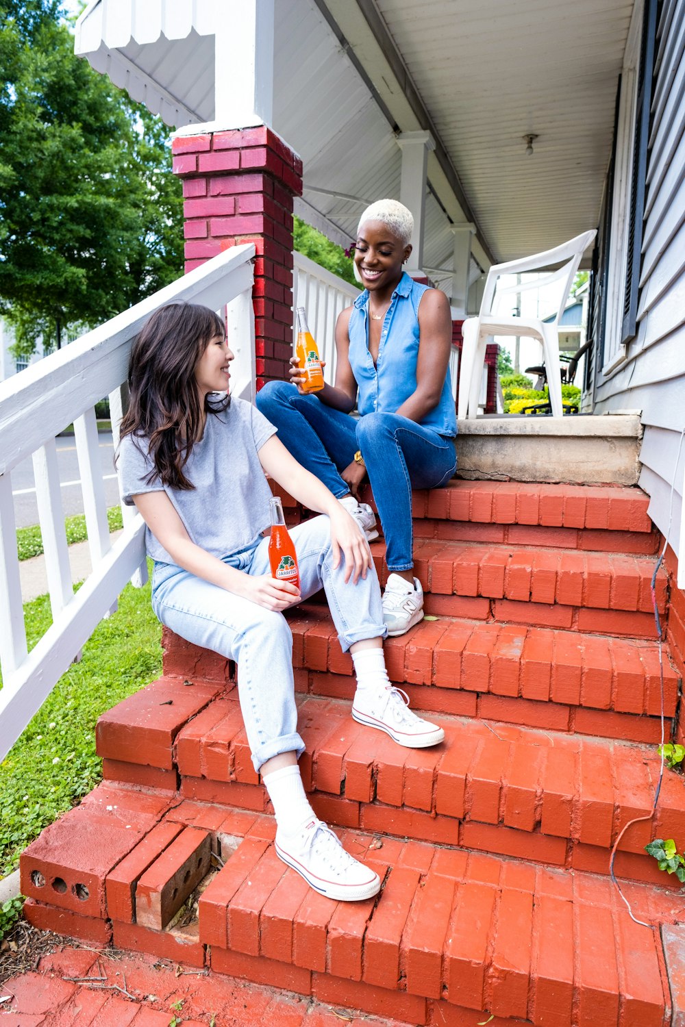 man and woman sitting on red concrete stairs