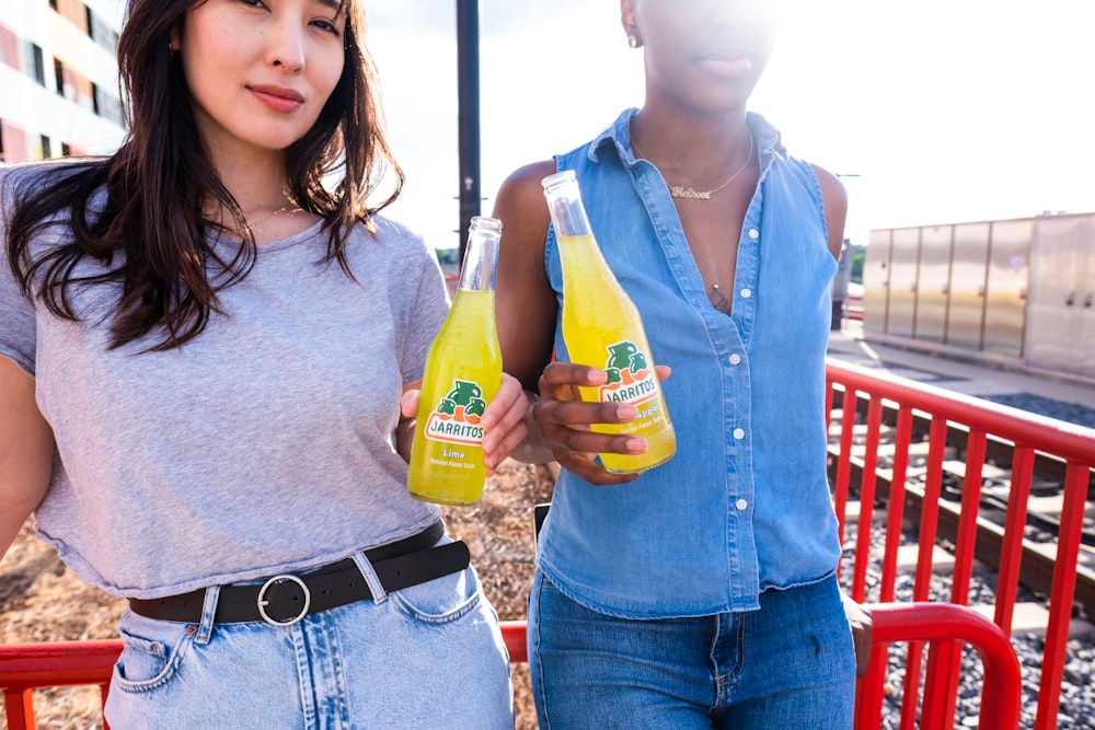 woman in gray shirt holding yellow bottle