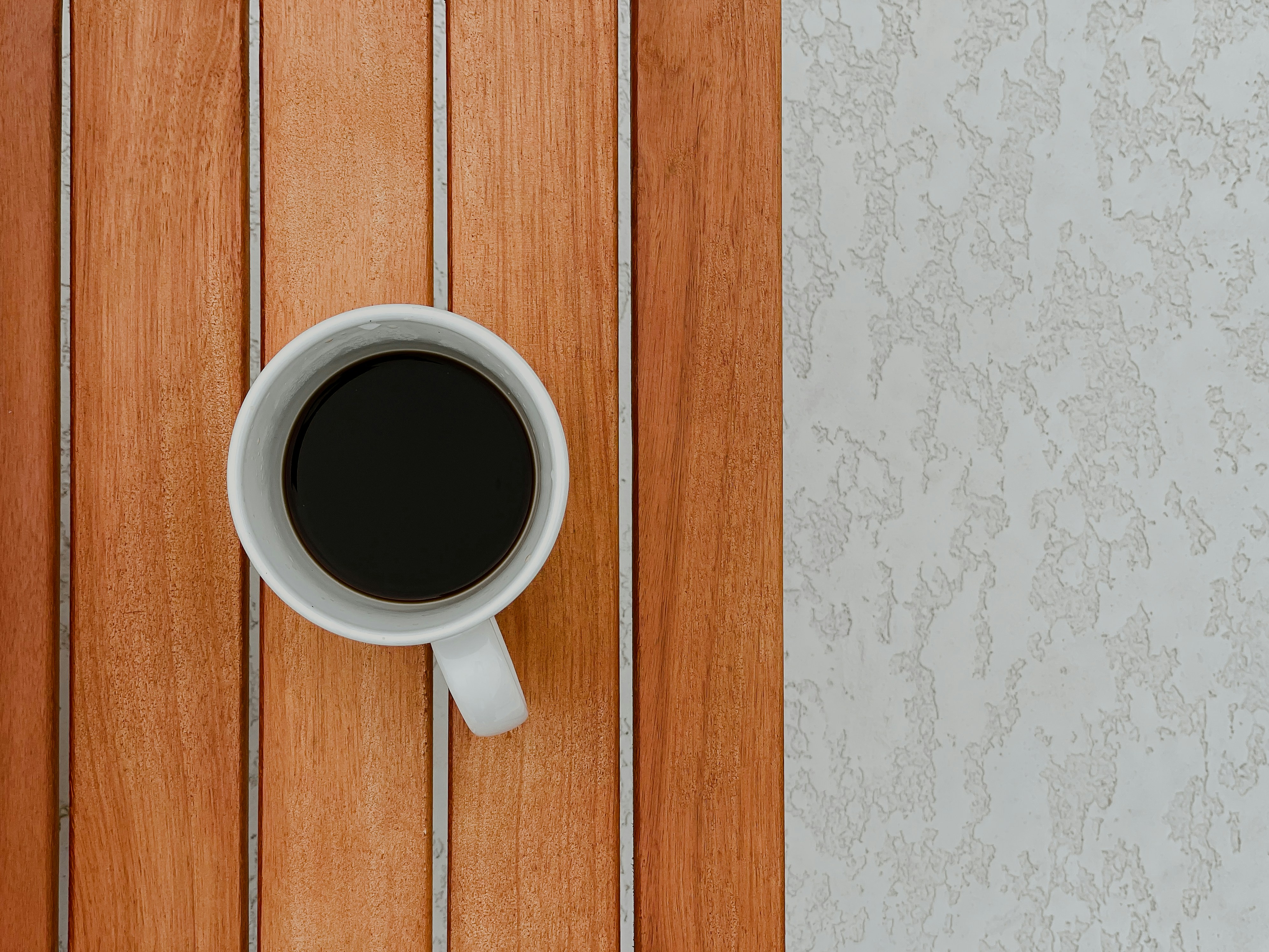 white ceramic mug on brown wooden table