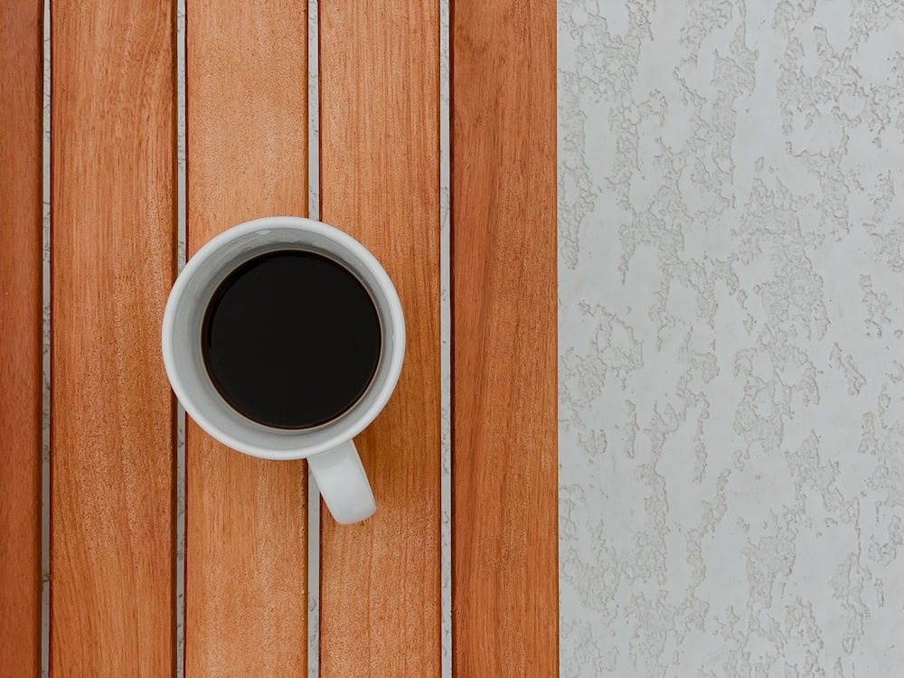 white ceramic mug on brown wooden table