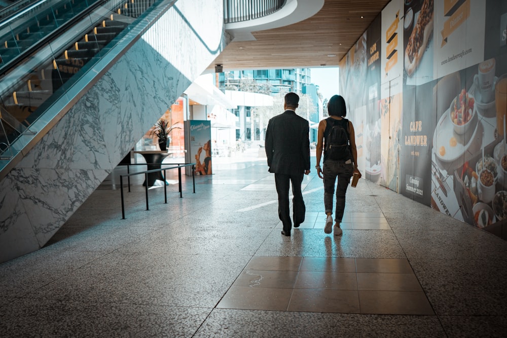 man and woman walking on hallway