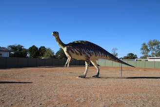 A roaring T-Rex standing against a cloudy prehistoric sky with distant mountains.