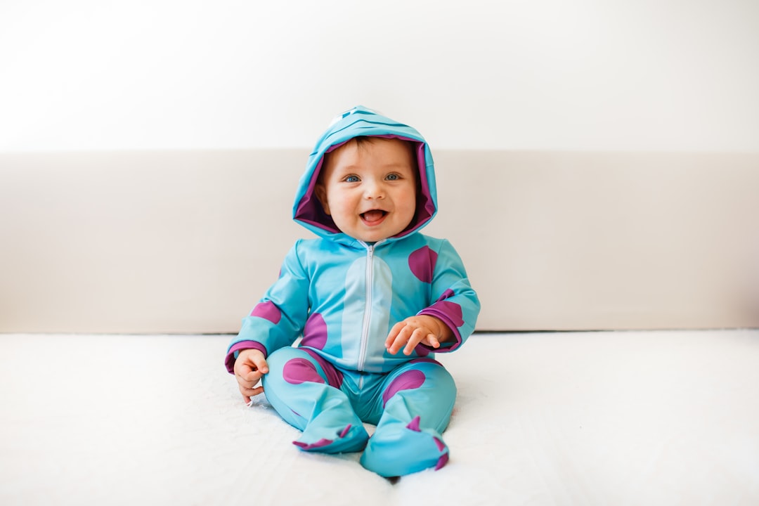 baby in blue hoodie and pants sitting on white floor