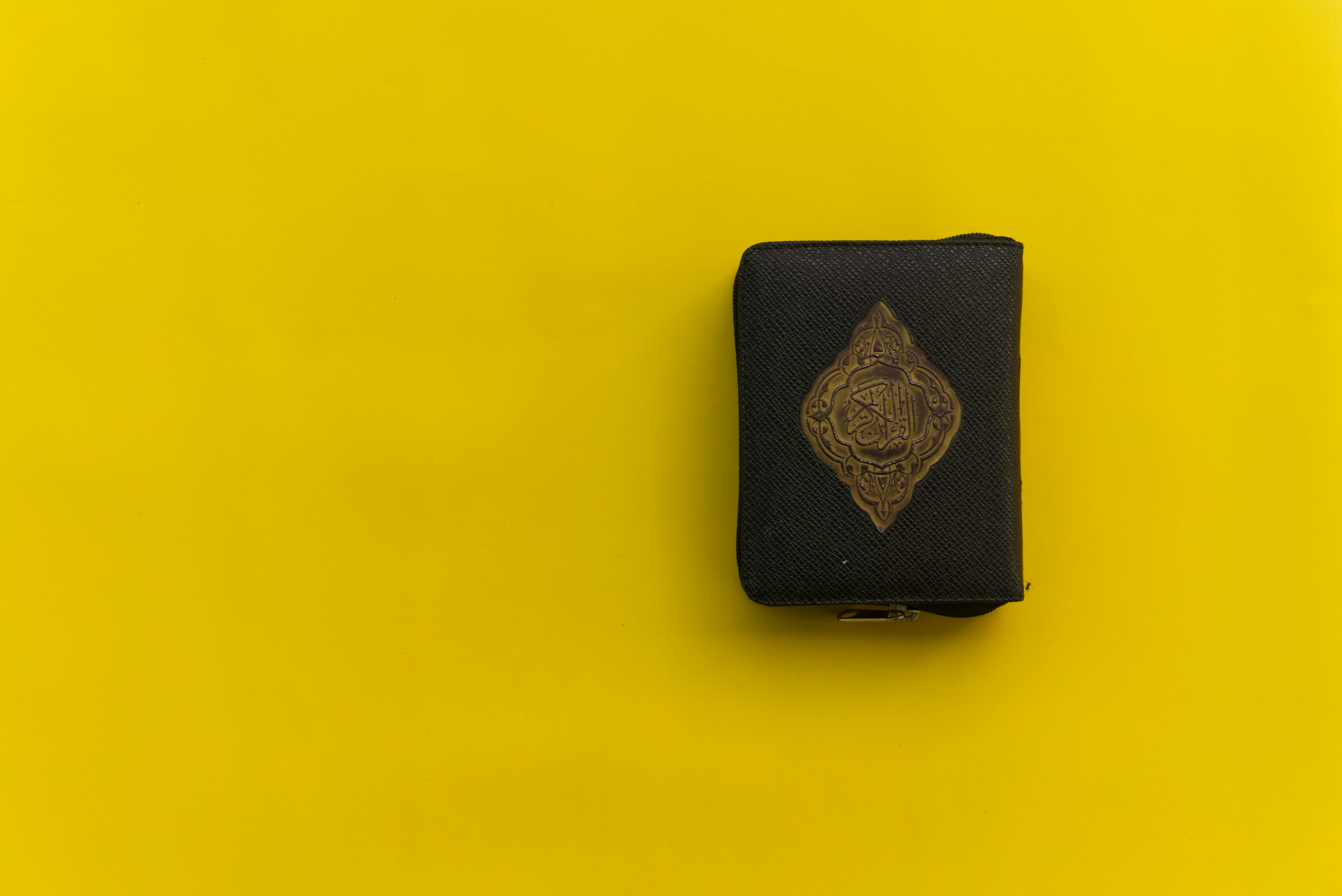 black leather wallet on yellow surface