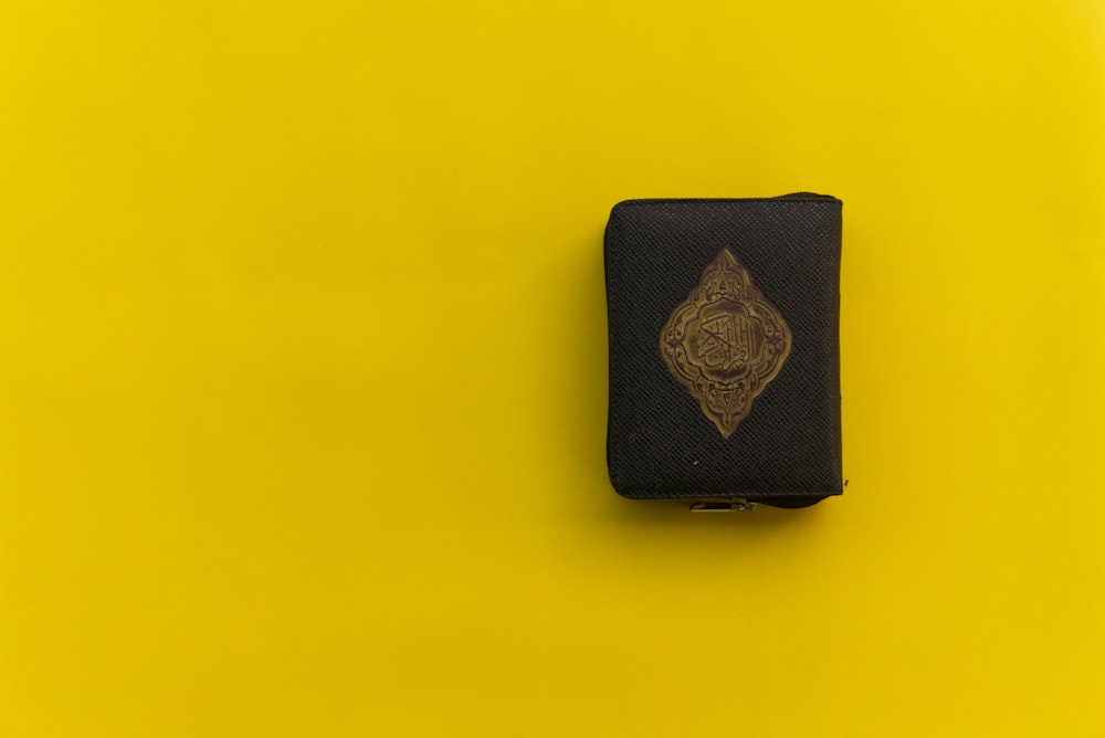 black leather wallet on yellow surface