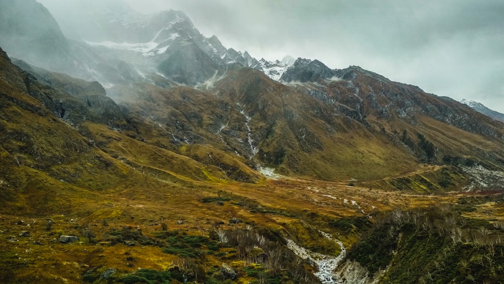 green and brown mountains under white clouds during daytime