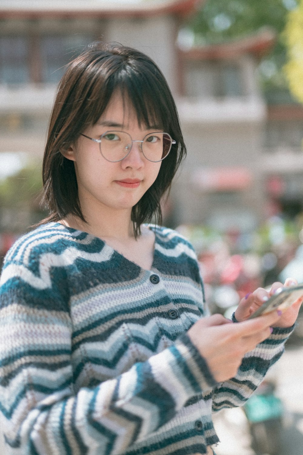 woman in green and white sweater wearing black framed eyeglasses