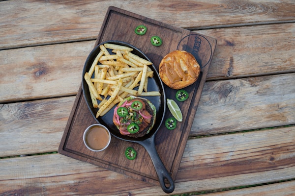 Pasta on brown wooden bowl beside black handled scissors