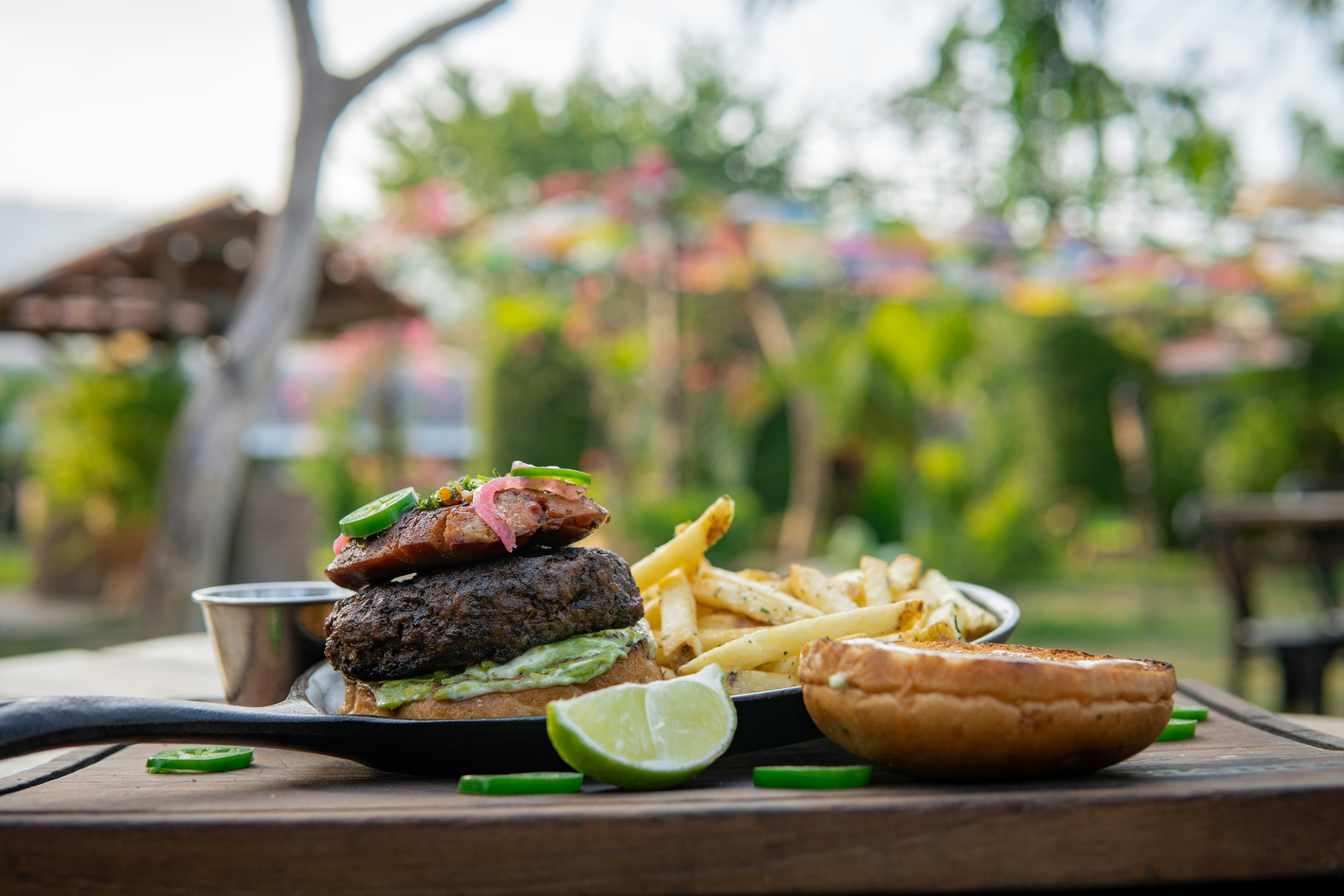 Burger and fries on a slate at an outdoor table