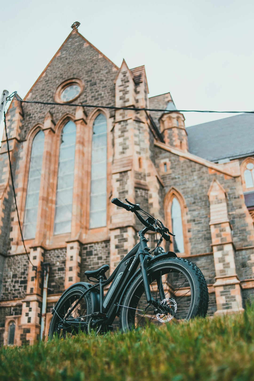 black bicycle parked beside brown concrete building during daytime