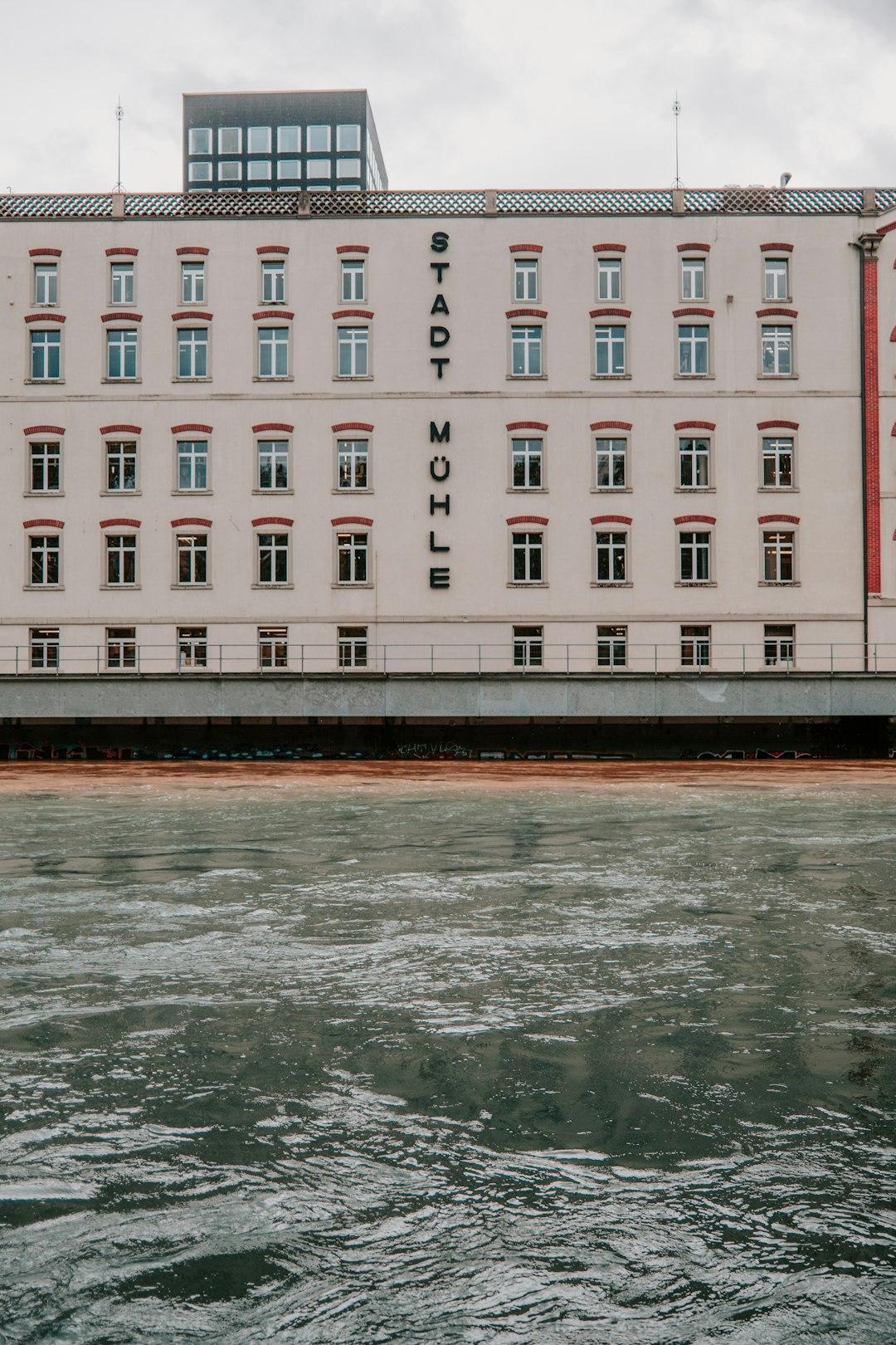 white and brown concrete building near body of water during daytime