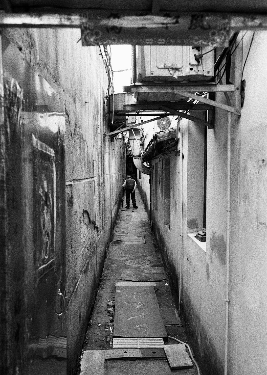 grayscale photo of a man walking on a hallway