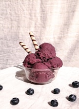 Vibrant sorbet scoops with fresh berries and mint leaves on a wooden table.