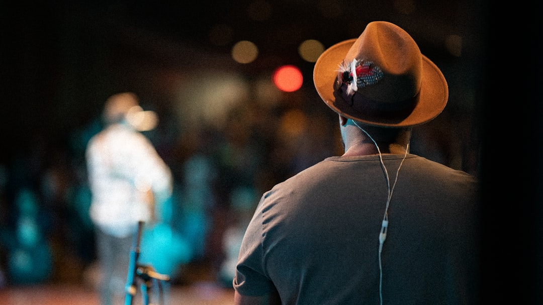 man in black shirt wearing brown fedora hat