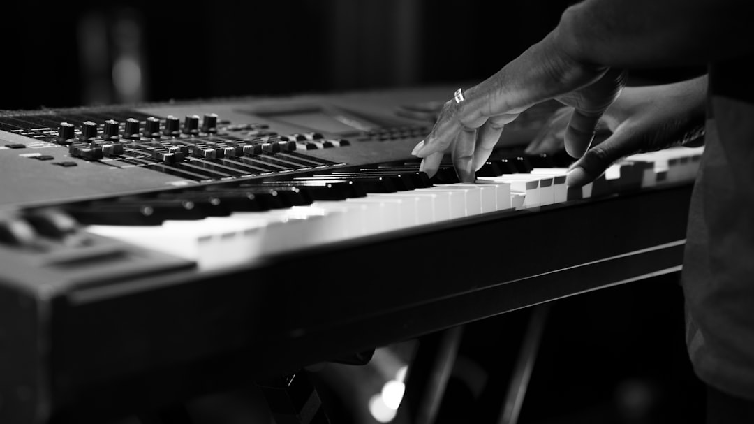 person playing piano in grayscale photography