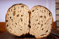 Sliced sourdough revealing its airy crumb texture against a matte charcoal backdrop.