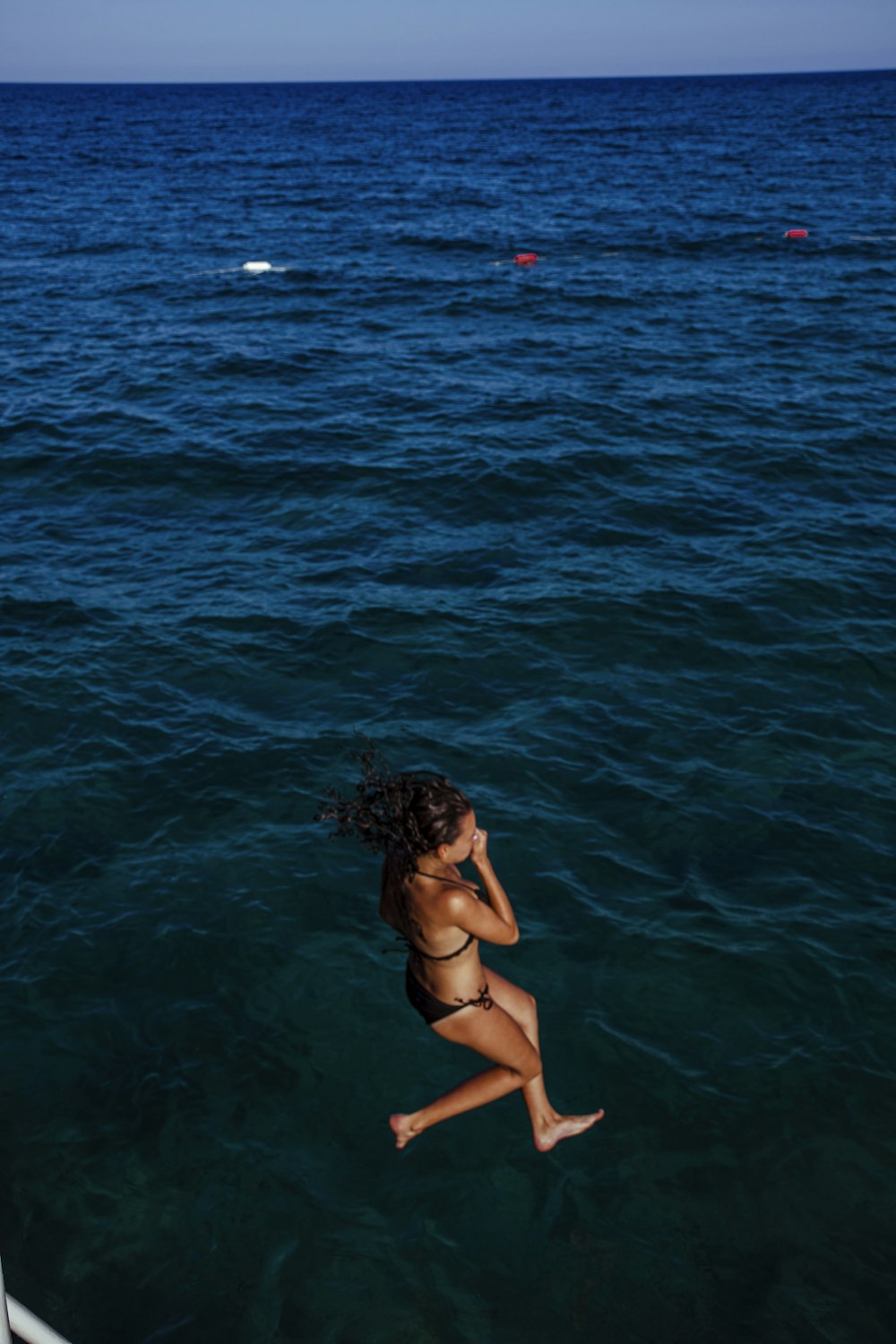 woman in black bikini top on water during daytime