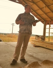 A technician advising a roofing team on-site, pointing to product features on a tablet.