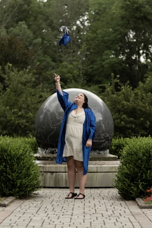 woman in blue and white dress standing on green grass field during daytime