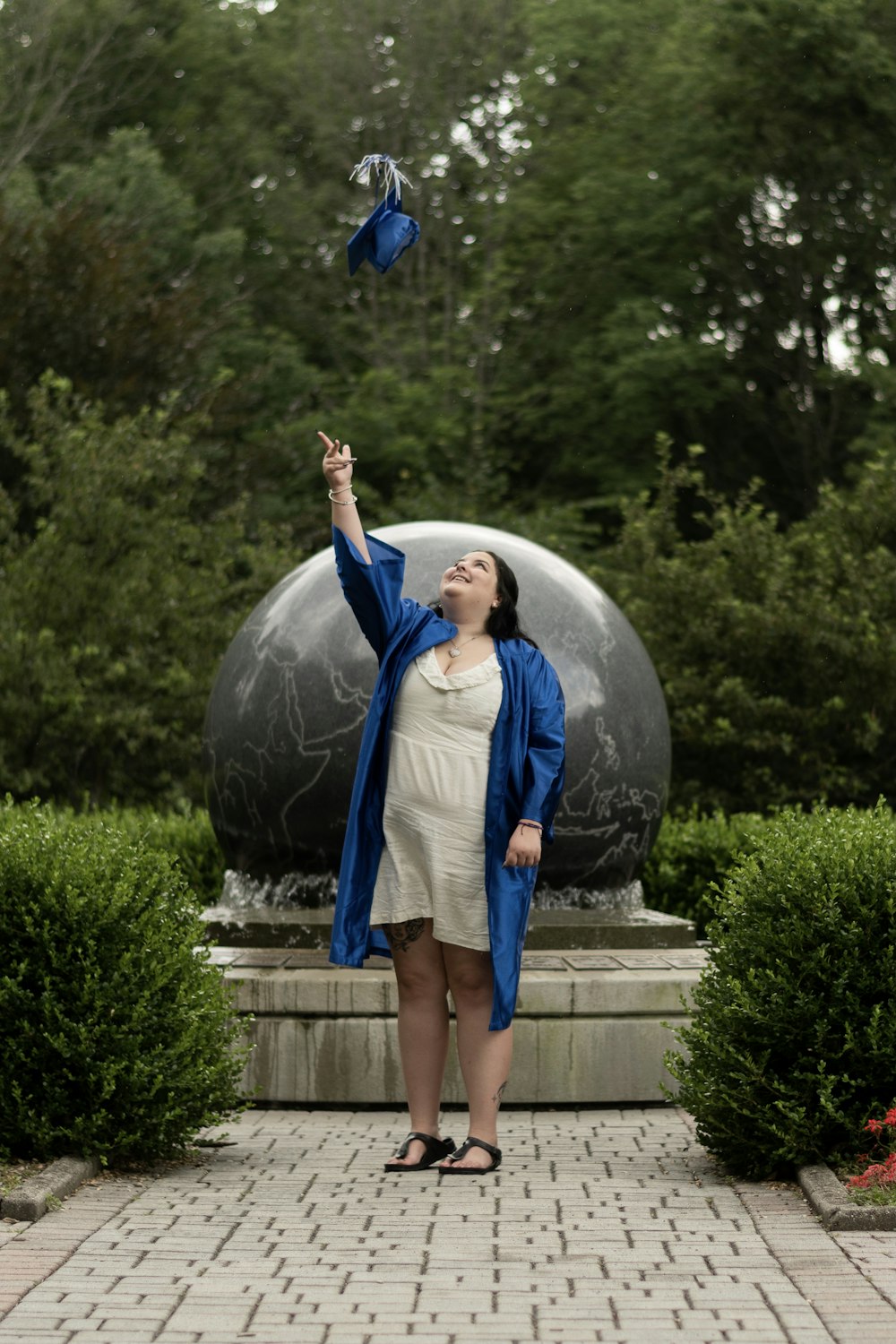 femme en robe bleue et blanche debout sur le champ d’herbe verte pendant la journée